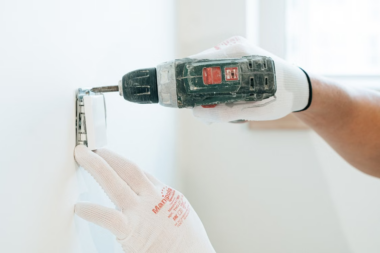 an electrician drilling into a wall. 